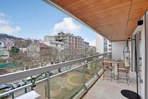 a balcony with a table and chairs and a view at Charming Apt with AC & balcony in Suresnes