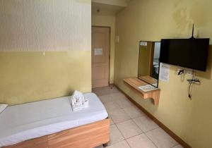 a room with a bed and a flat screen tv at JL Suites by Hiverooms in Cebu City