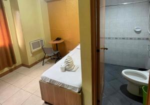a bathroom with a bed and a shower and a toilet at JL Suites by Hiverooms in Cebu City +7 photos