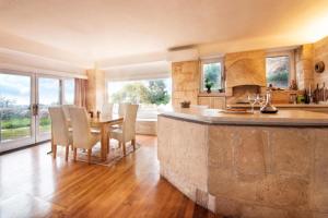 a large kitchen with a table and chairs and a counter at Majestique Villa Aegina in Egina +31 photos
