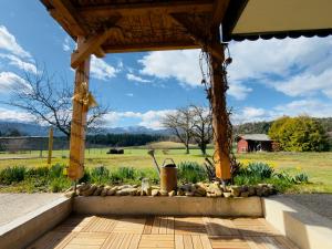 a wooden gazebo with a field in the background at Einfach bei uns in Fresach
