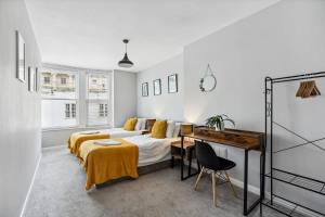 a bedroom with a bed and a desk in it at 'Bright Gem by the Sea' Premium Central 2 bedroom flat in Brighton & Hove