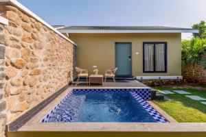 a swimming pool in front of a house at Merriment Luxury Resort & Private Pool Villa Near Mount Abu, Abu Road in Bhīmānia