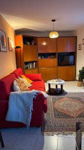a living room with a red couch and a table at casa di Gio in Sondrio