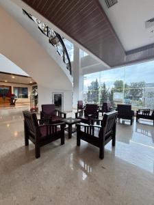 a lobby with chairs and a table and a chandelier at Zam Hotel By Pavotel in Kedungbadak