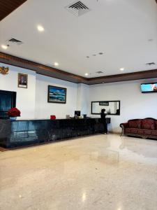 a person standing in a large room with a couch at Zam Hotel By Pavotel in Kedungbadak +42 photos
