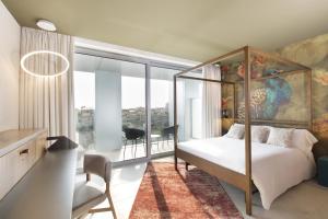 a bedroom with a canopy bed and a large window at Hotel SB Glow 4 Sup in Barcelona