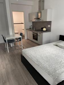 a bedroom with a bed and a table and a kitchen at LuxAppartement Trier in Trier