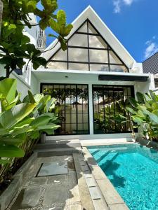 a house with a swimming pool in front of a house at Gauri Vasanta Villa with Private Pool Yogyakarta in Yogyakarta