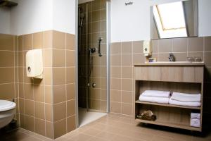 a bathroom with a shower and a toilet and a sink at Levendula Hotel in Algyő +51 photos