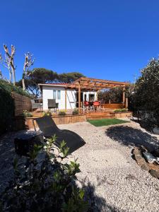a backyard with a wooden pergola and a house at Chalet Cosy 6 personnes in Gassin