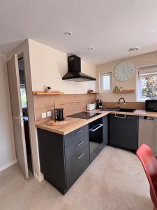 a kitchen with a sink and a clock on the wall at Chalet Cosy 6 personnes in Gassin +26 photos