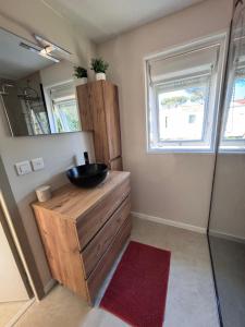 a bathroom with a sink on top of a wooden cabinet at Chalet Cosy 6 personnes in Gassin