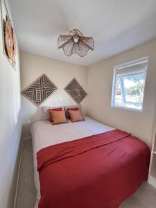 a bedroom with a large bed with a red blanket at Chalet Cosy 6 personnes in Gassin