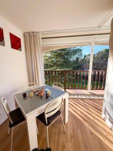 a white table and chairs in a room with a balcony at L'Ecrin du Verdon - T2 avec Balcon in Gréoux-les-Bains