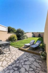 a patio with a table and chairs on a stone patio at Maison des Sens in Saint-Omer