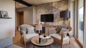 a living room with chairs and a table and a tv at Butični Hotel Sončno Polje in Moravske-Toplice