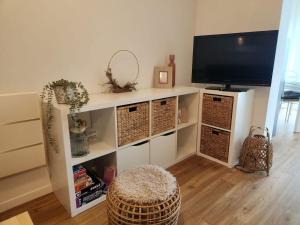 a living room with a white entertainment center with a flat screen tv at L'Ecrin du Verdon - T2 avec Balcon in Gréoux-les-Bains
