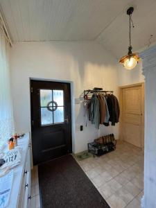 a kitchen with a black door and a room with clothes at Garden Lodge Minou in Hirschwang