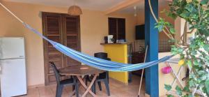 a hammock in a kitchen with a table and a refrigerator at LEFOUXIOL in La Trinité
