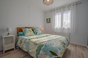 a bedroom with a bed with a colorful comforter and a window at Le marguette in Poivres