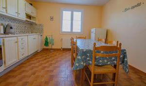 a kitchen with a table and chairs and a refrigerator at Le marguette in Poivres