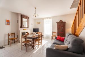 a living room with a couch and a table at Les Géraniums - Maison avec terrasse - Baden in Baden