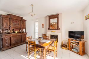 a living room with a dining room table and a tv at Les Géraniums - Maison avec terrasse - Baden in Baden