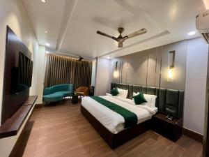 a hotel room with a bed and a tv at Hotel Mango Groves in Kotdwāra