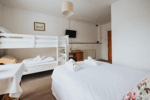 two beds in a hotel room with white beds at Y Pengwern in Ffestiniog