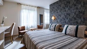 a bedroom with a bed and a desk and chairs at Hostellerie Saint Germain in Saint-Germain-lès-Arlay