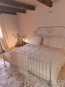 a bedroom with a large bed with a metal frame at L'Amour Toujours in Saint-Julien-le-Petit