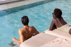 a couple of people sitting in a swimming pool at Hotel SB Glow 4 Sup in Barcelona