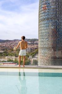 a man standing on the edge of a swimming pool at Hotel SB Glow 4 Sup in Barcelona