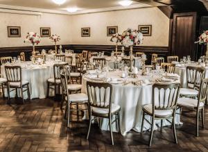 a banquet room with tables and chairs with flowers at Hotel - Bar Grafaite in Šiauliai +90 photos