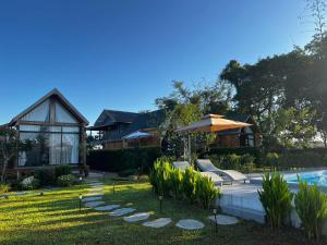 a house with a swimming pool and an umbrella at Tuyo Homestay in Ban Pang Kiang