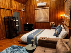 a bedroom with a large bed and a couch at Tuyo Homestay in Ban Pang Kiang