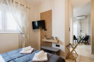 a bedroom with a bed and a tv on the wall at Zoe's Luxury Living in Volos