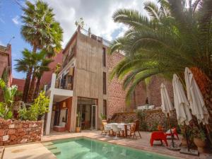 a villa with a swimming pool in front of a house at Palais Laila in Tighfert