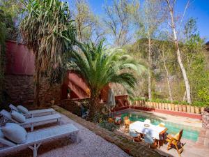 a backyard with a pool with a table and chairs at Palais Laila in Tighfert