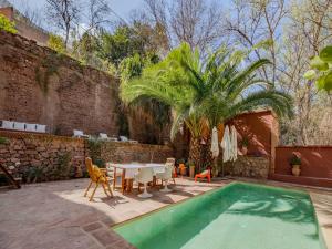 a patio with a table and chairs and a pool at Palais Laila in Tighfert