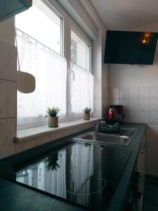 a kitchen with a sink and a window next to a sink at Ferienwohnung Nauen in Nauen