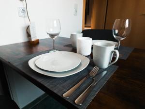 a table with a plate and two wine glasses at Ferienwohnung Nauen in Nauen +29 photos