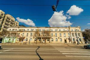 a large white building on a street with a crosswalk at Central Park Apartment 4 Guests in Chişinău