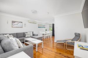a living room with a couch and a table at Barefoot Bungalow in Nelson Bay