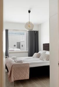 a bedroom with a large bed and a window at Funky City Apartment By Lapland Host in Rovaniemi