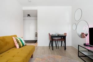 a living room with a yellow couch and a table at Funky City Apartment By Lapland Host in Rovaniemi