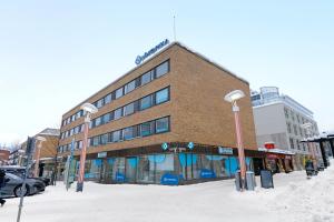 a building on a street with snow in front of it at Funky City Apartment By Lapland Host in Rovaniemi