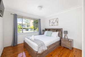a bedroom with a large bed and a window at Barefoot Bungalow in Nelson Bay