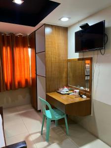 a room with a desk with a chair and a television at YMCA of Manila Hostel in Sampong
